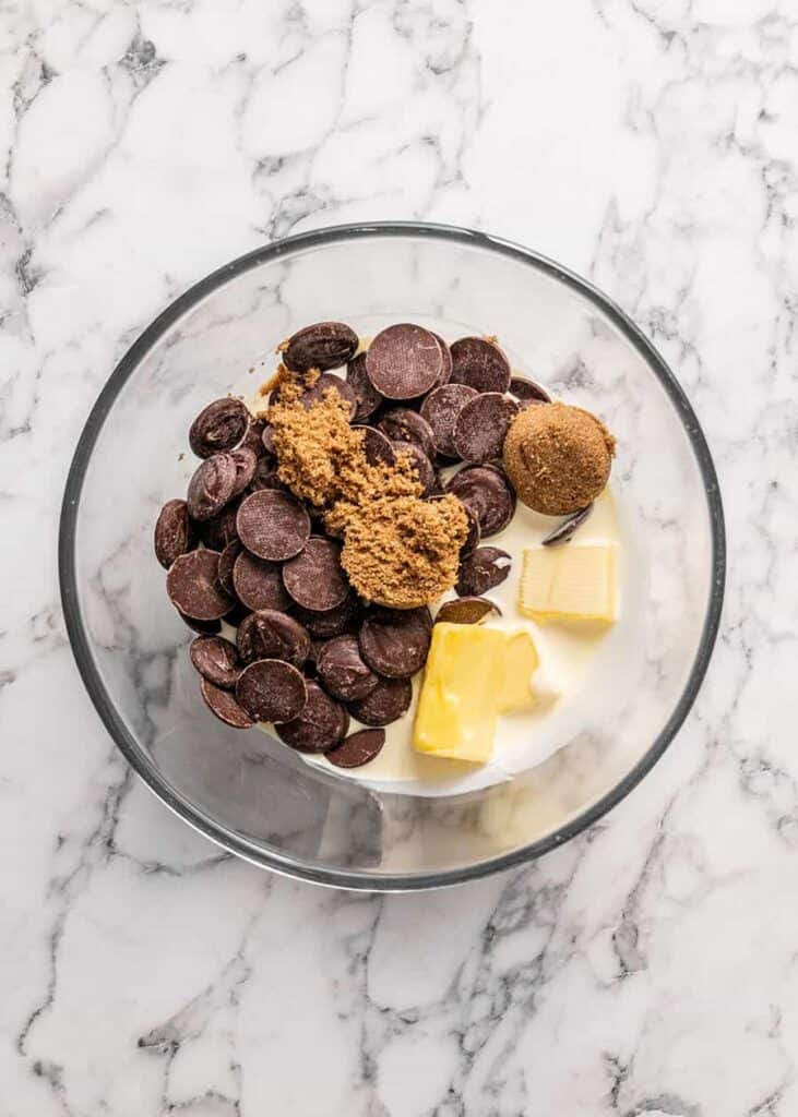 Adding all the ingredients into one bowl to make chocolate sauce for a boston cream pie