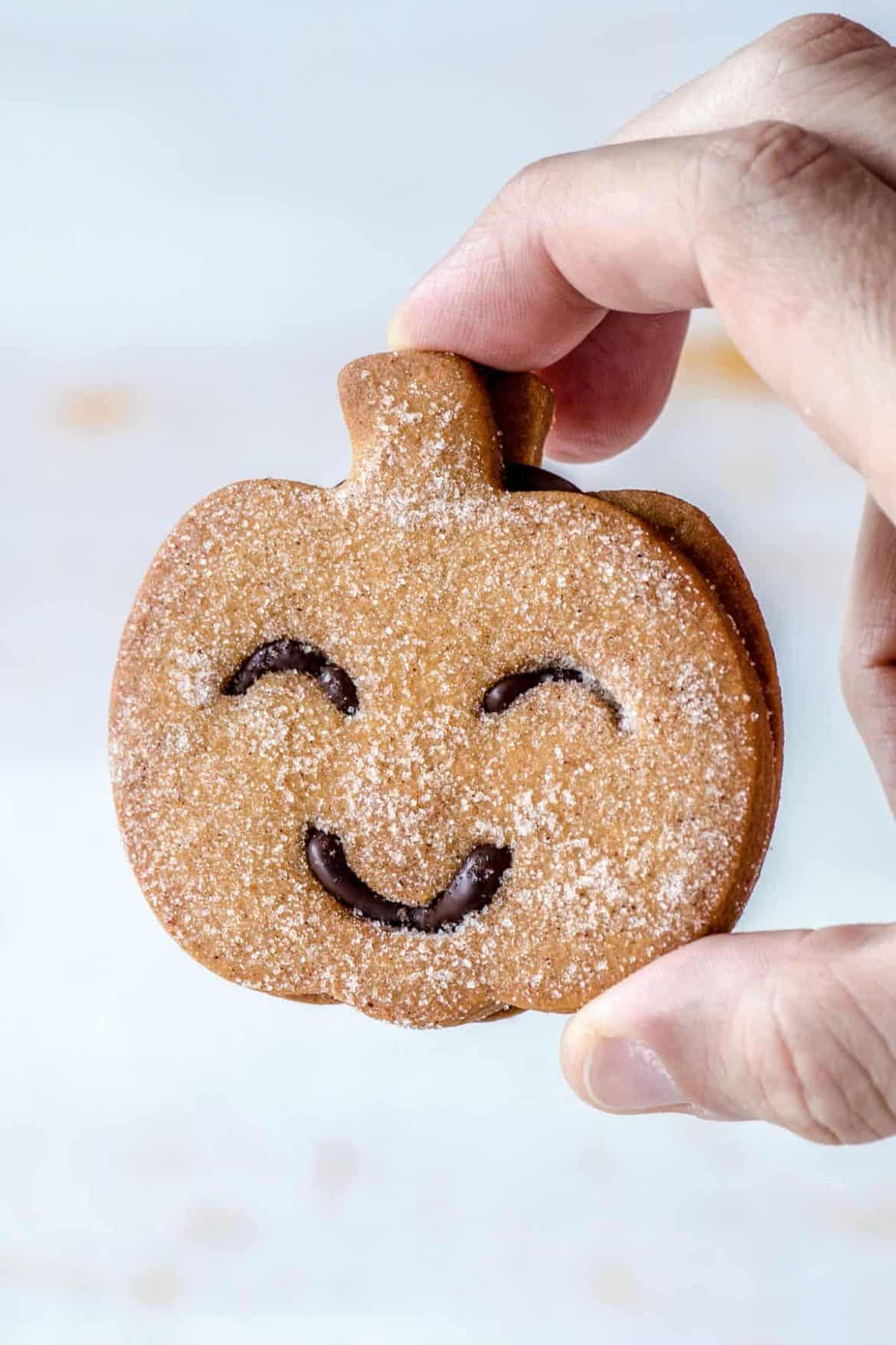 Hand holding a Pumpkin Halloween Cookie