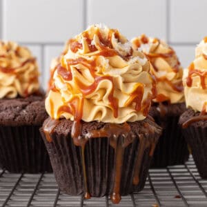 A chocolate cupcake filled with caramel sauce on a cooling rack