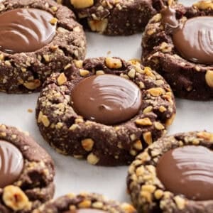 Chocolate thumbprint cookies coated in crushed nuts with a smooth chocolate center.