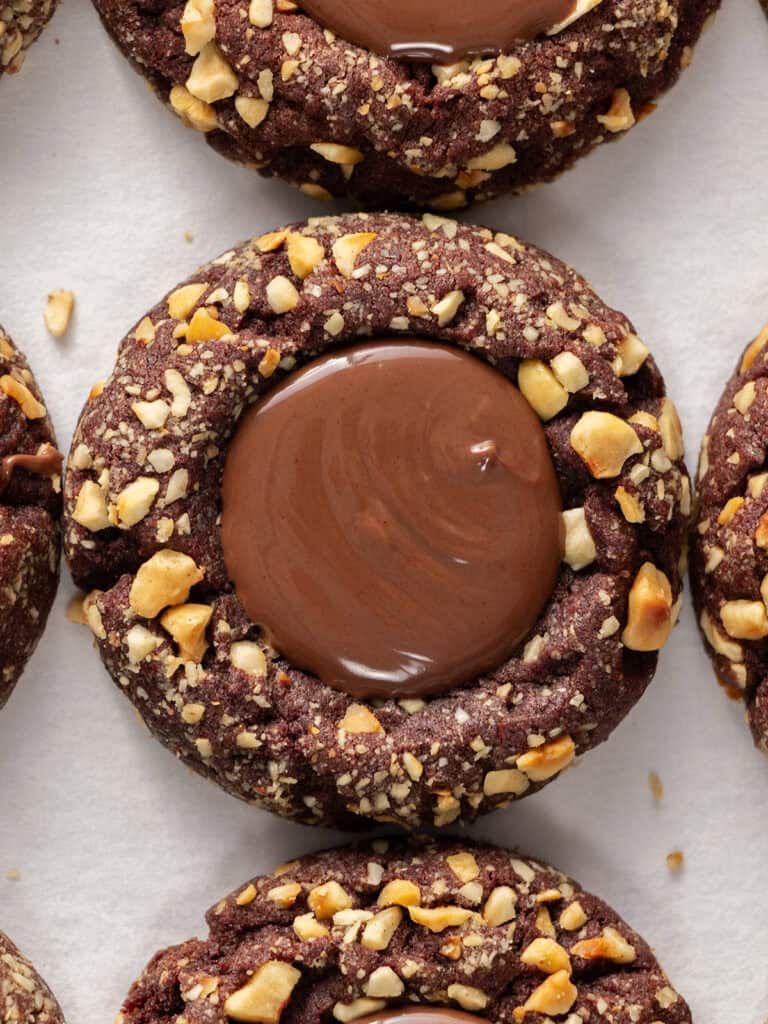 Chocolate thumbprint cookies coated in chopped nuts with a smooth chocolate center.