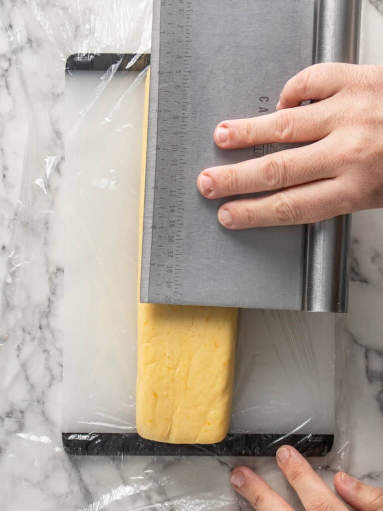 Flattening the top of the cookie dough to form into a rectangle log