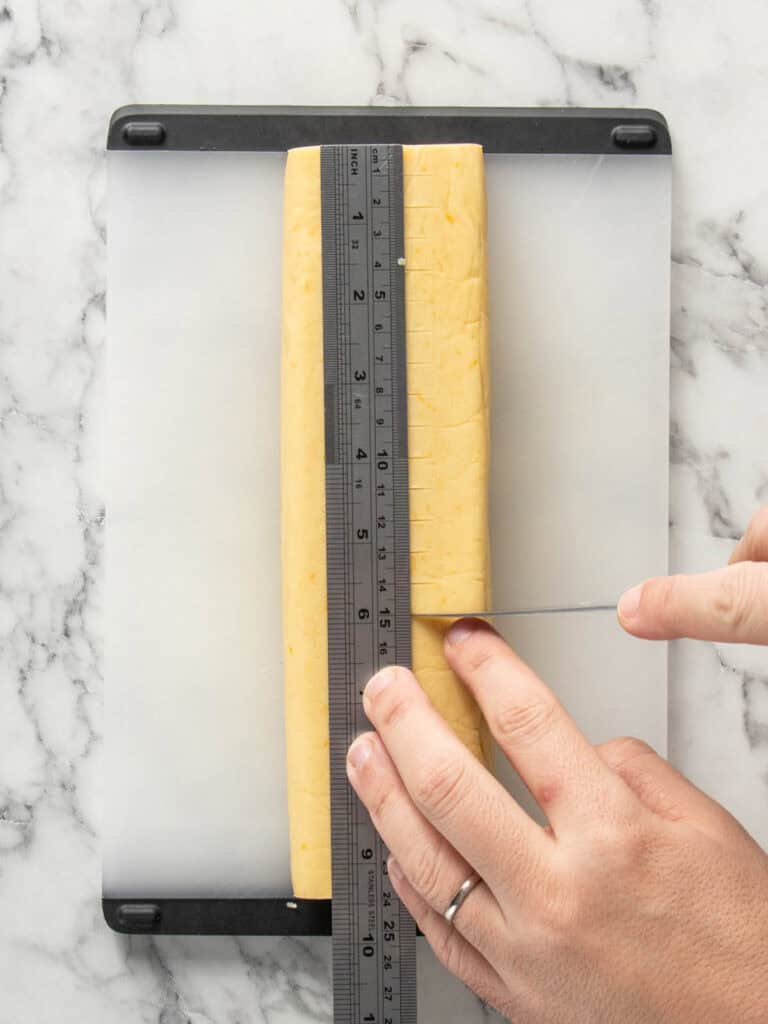 Using a ruler to measure out the size to slice cookies evenly.