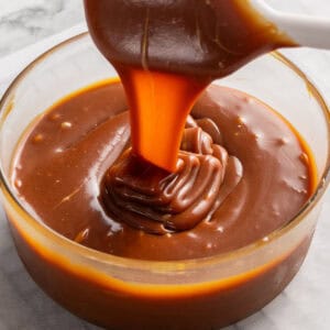 Square image of sauce falling in a ribbon off a spatula.