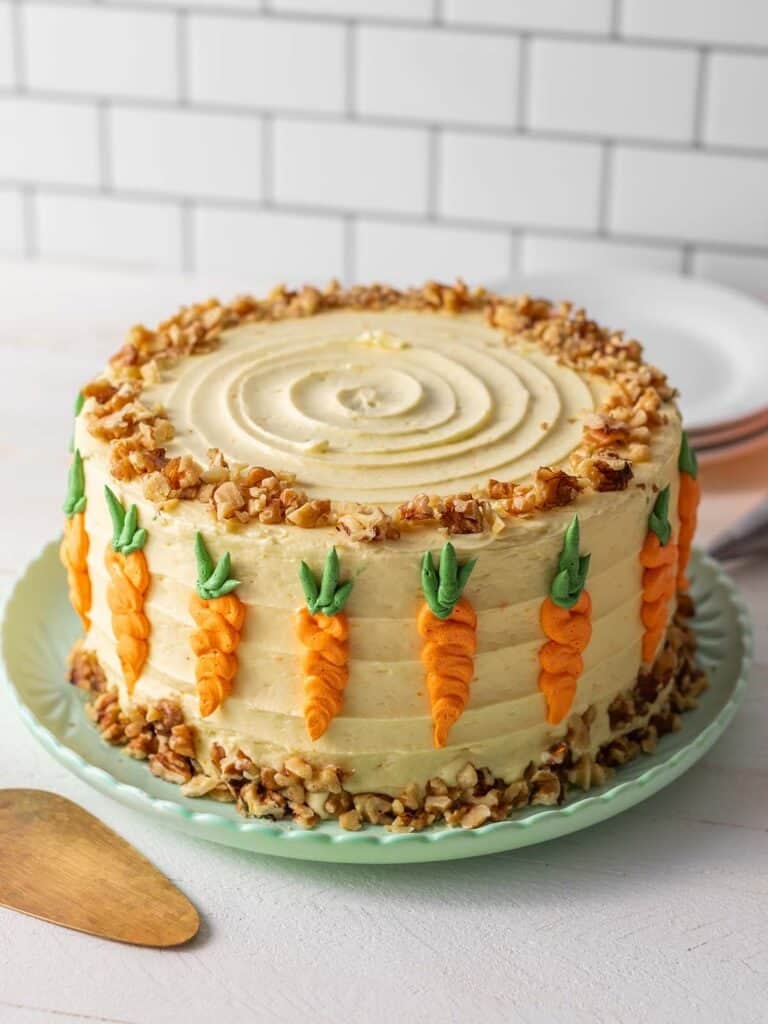 a full decorated cake with carrot decorations and walnuts on the outside