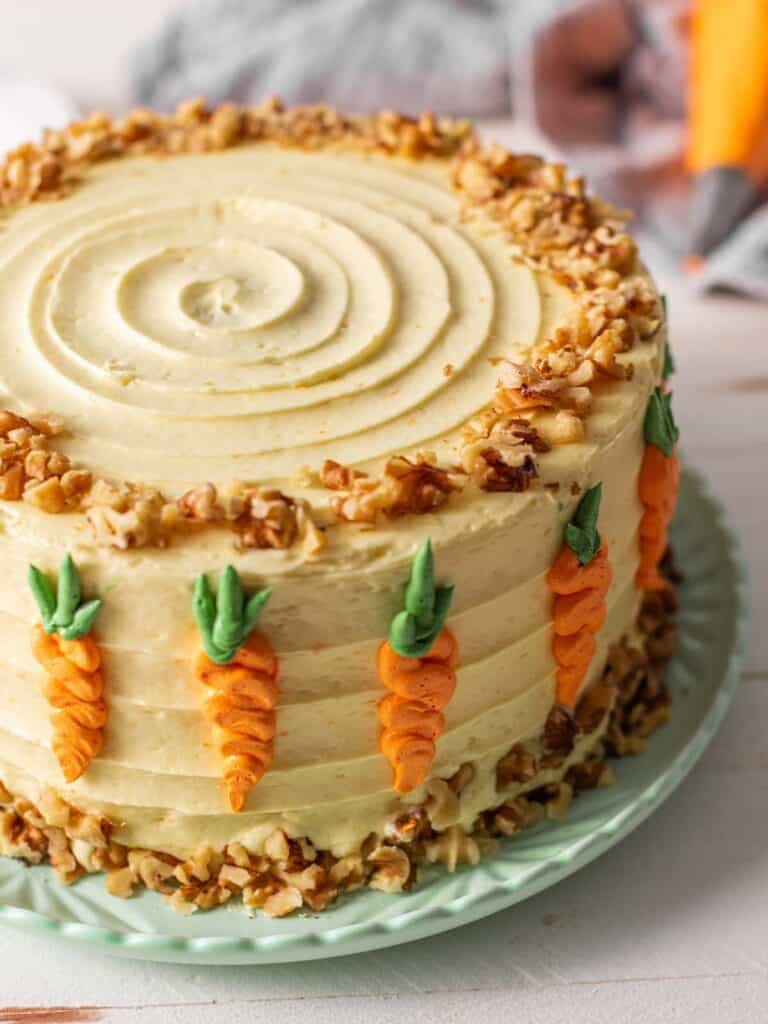 A close up shot of the carrot decorations on the frosted cake