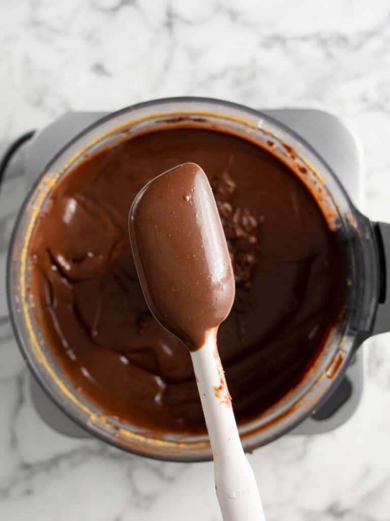 Showing what the chocolate custard cream looks like on a spatula. Glossy and smooth