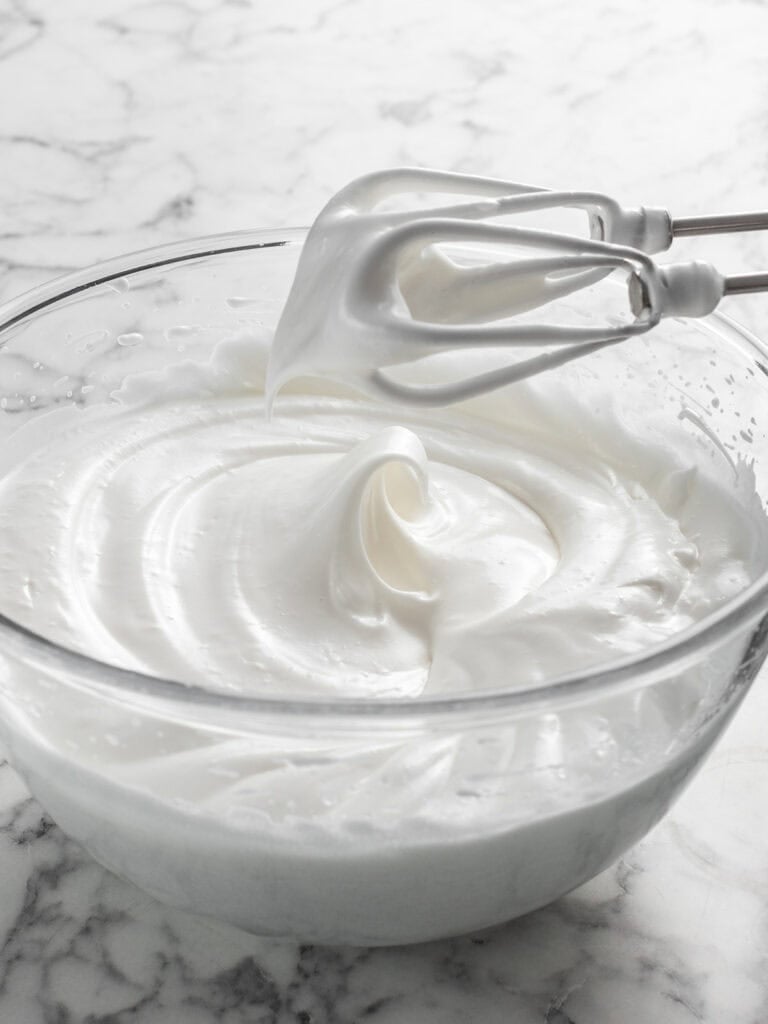 Showing how thick and glossy the meringue looks once it's been whipped to stiff peaks