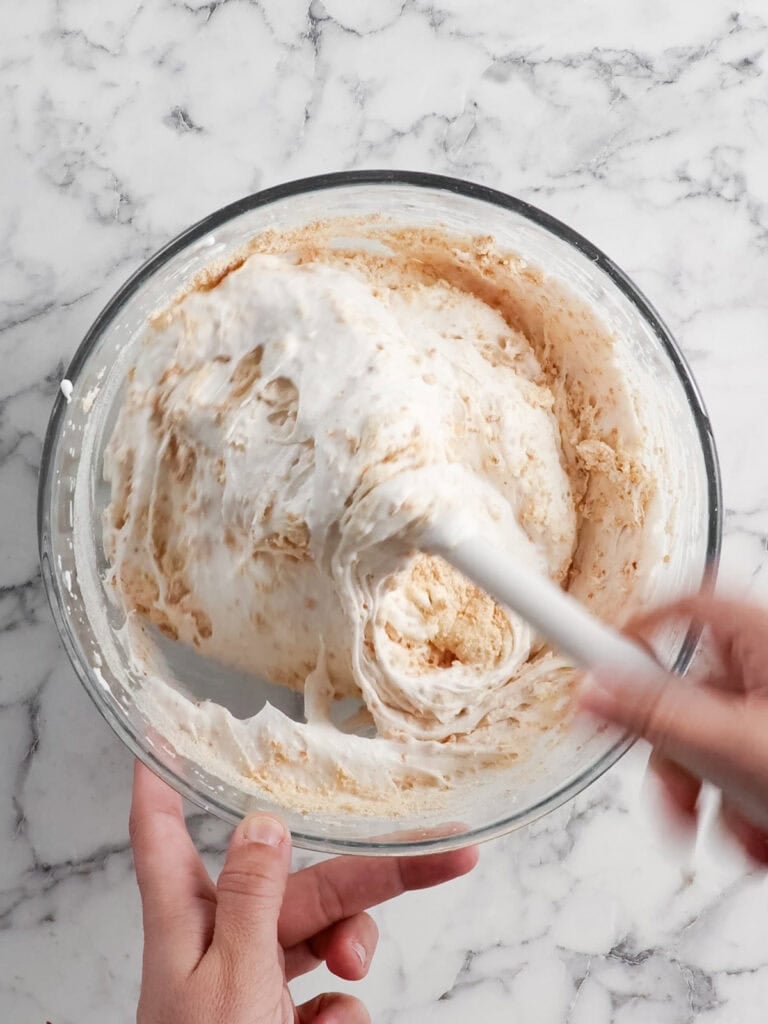 Folding the hazelnut meal through the meringue to form the batter