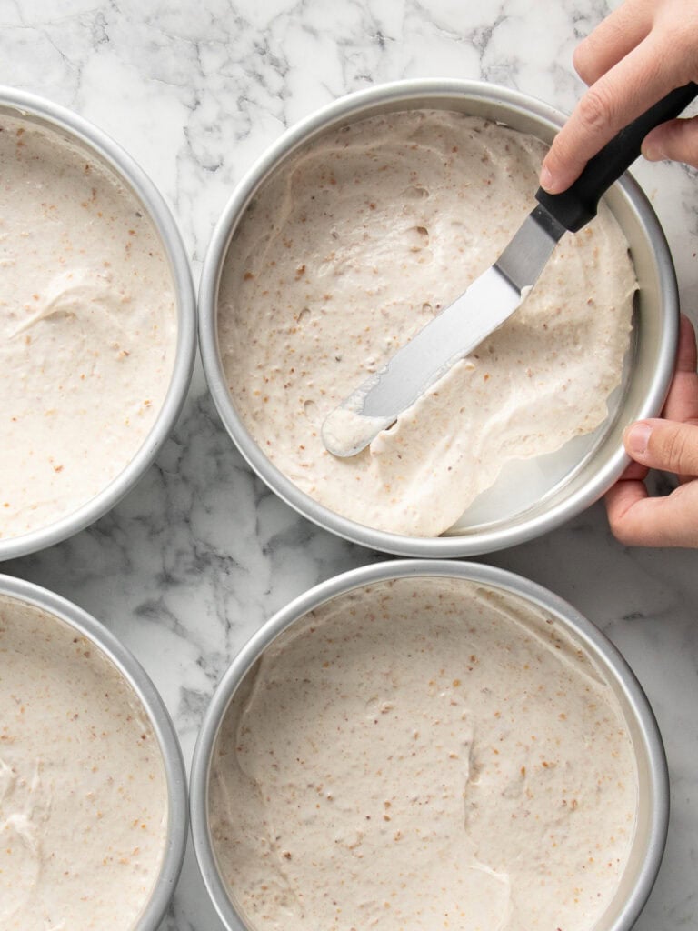 Spreading the mixture in cake tins to get them ready to bake
