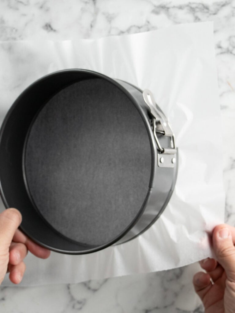 Adding baking paper to the bottom of your springform pan before layering the cake