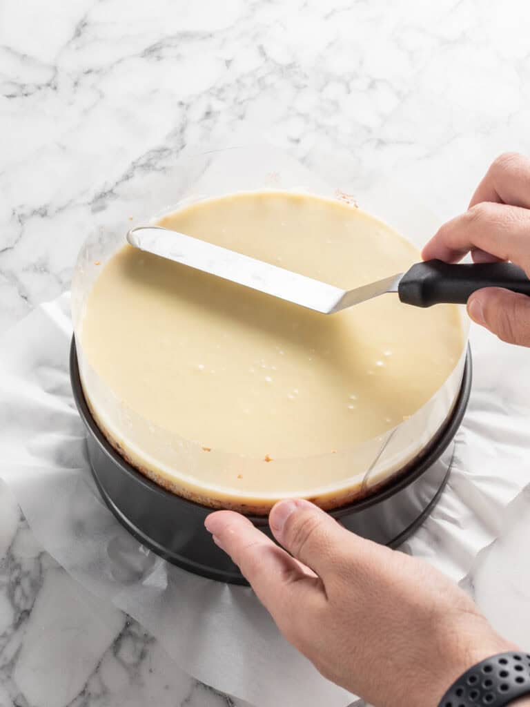 Levelling off the glaze on top of the layered cake