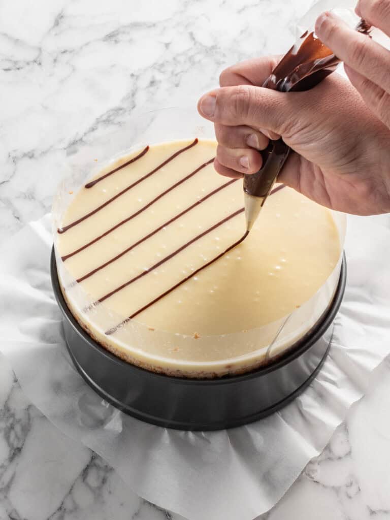 Piping the chocolate glaze on top of the vanilla glaze