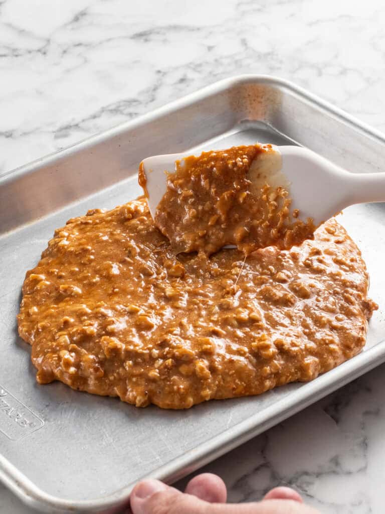 Adding the mixture to a baking tray to set