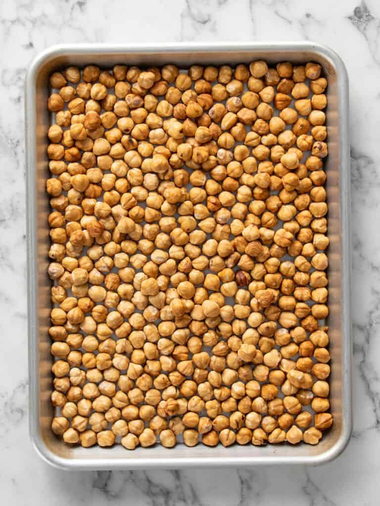 Top down shot of the toasted hazelnuts in a baking tray