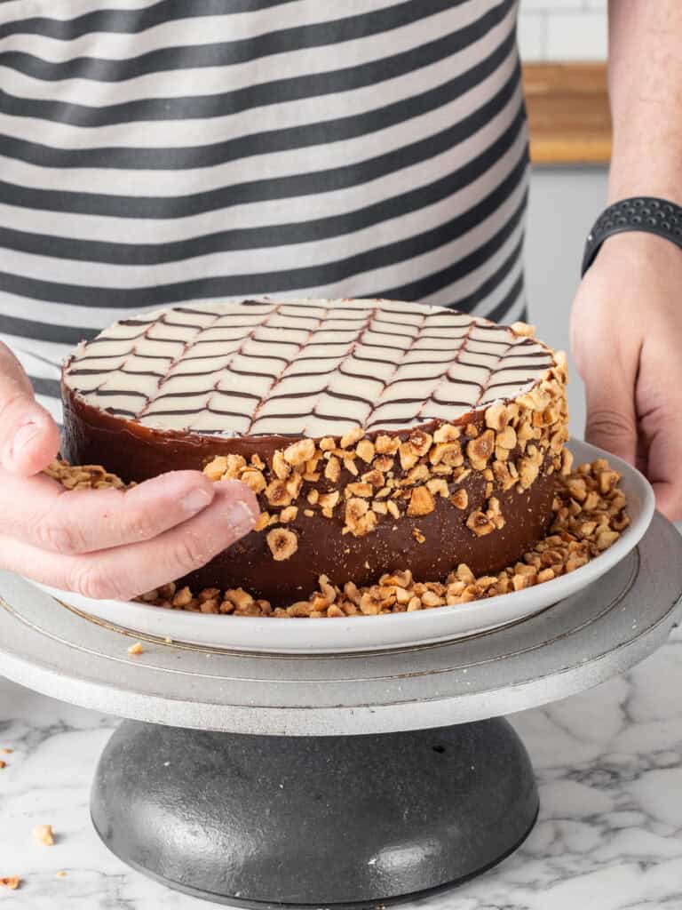 Adding the hazelnuts to the side of the cake