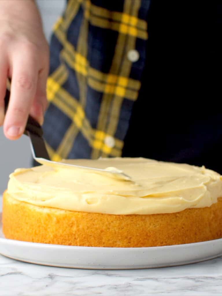Adding the custard to the cake sponge and spreading it around evenly