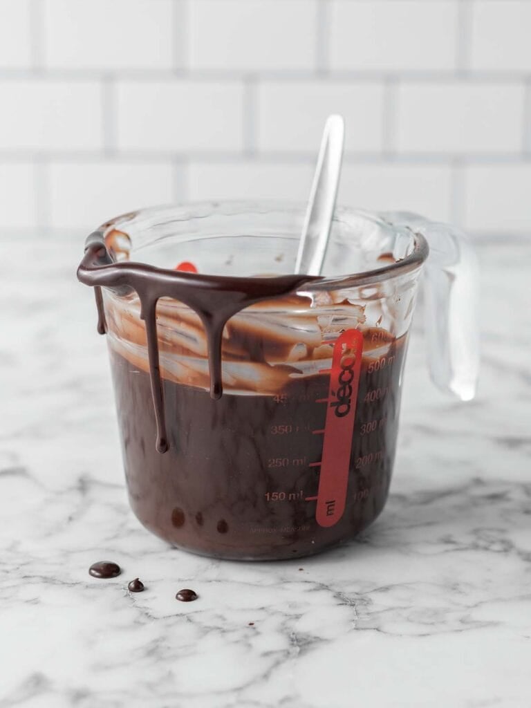 Fudge sauce coming out of a jug dripping down the sides