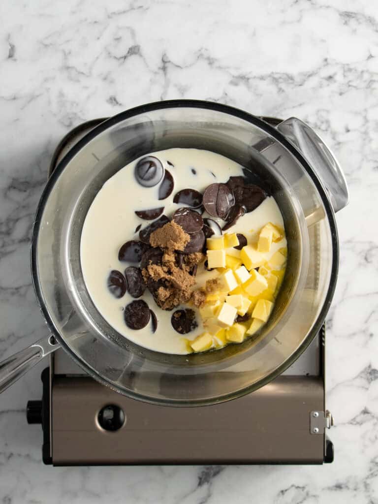 Adding the fudge sauce ingredients into the heatproof bowl on top of a double boiler