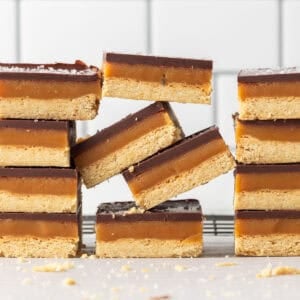 Square image of an uneven stack of caramel and shortbread bars