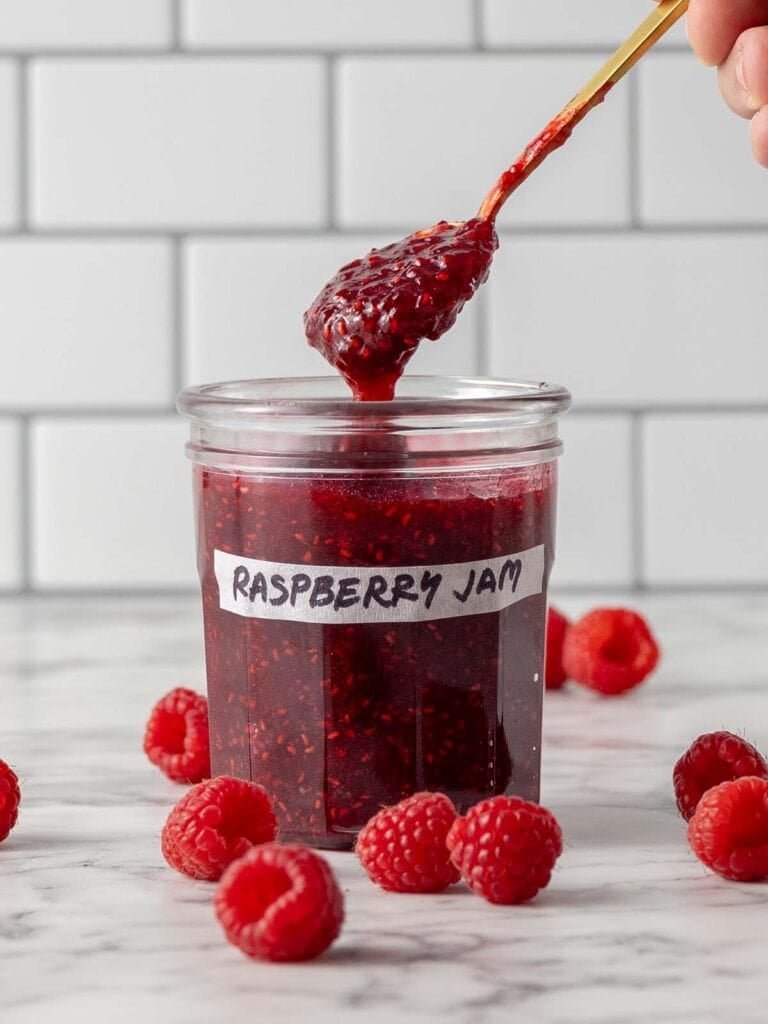 Spoon taking out jam from a glass jar