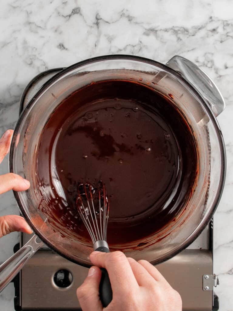 Whisking the butter, chocolate and cocoa powder over a double boiler