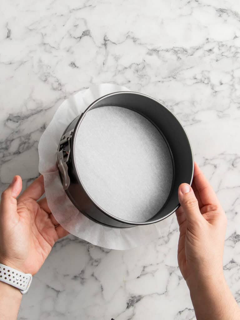 Showing what the springform pan looks like with the baking paper lined at the bottom