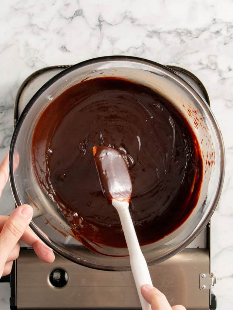 adding the cream and gelatin to the chocolate and whisking until smooth