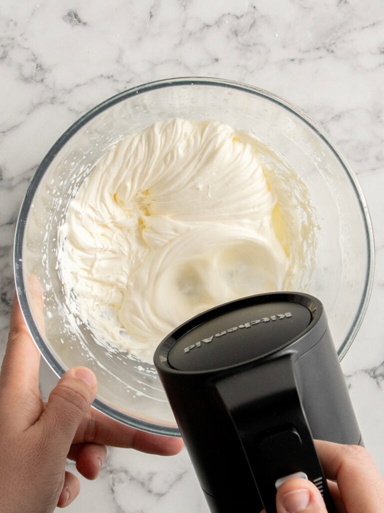 Whisking the cream to stiff peaks