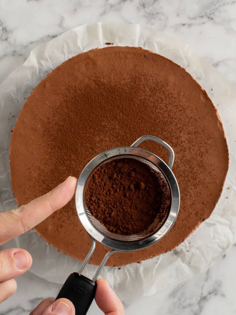 Dusting the top of the set mousse with cocoa powder