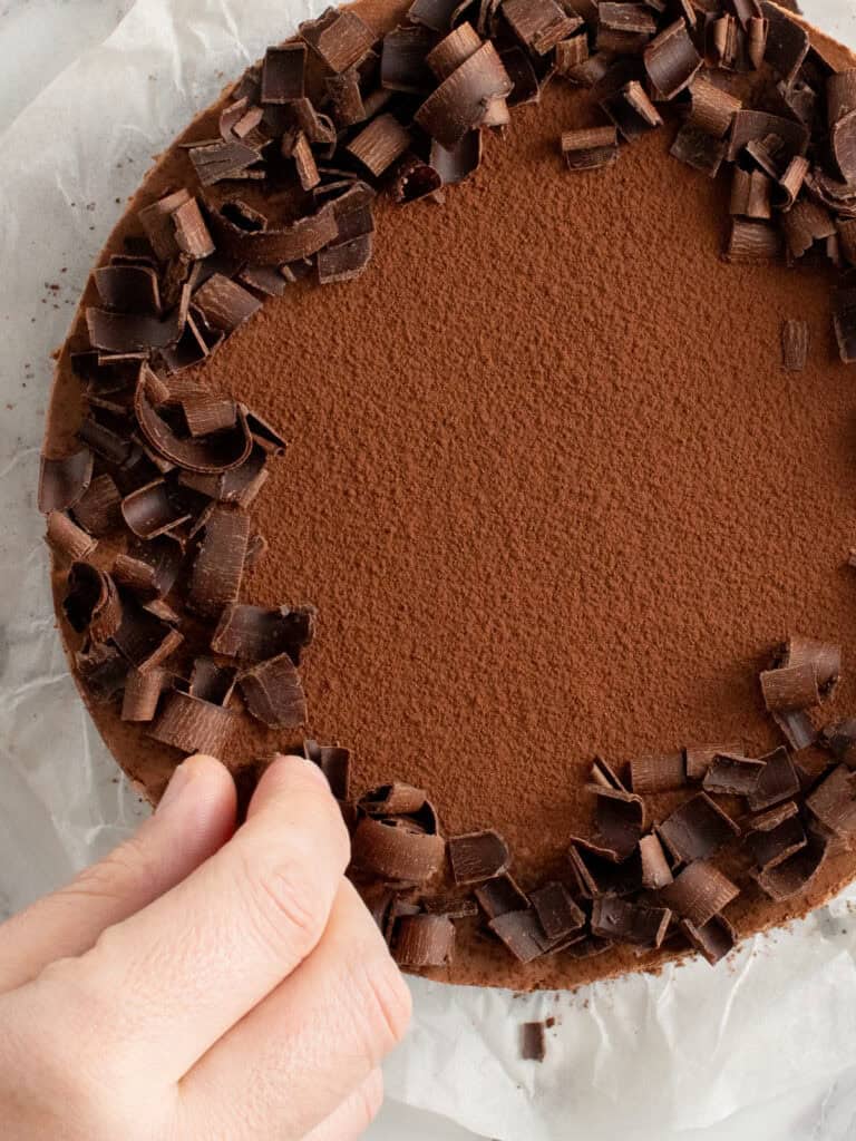 Adding the chocolate curls on top of the mousse layer to finish the cake