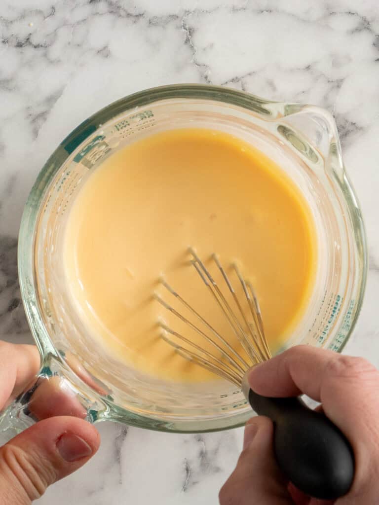 Whisking the egg yolks and cream and then gently heating in the microwave