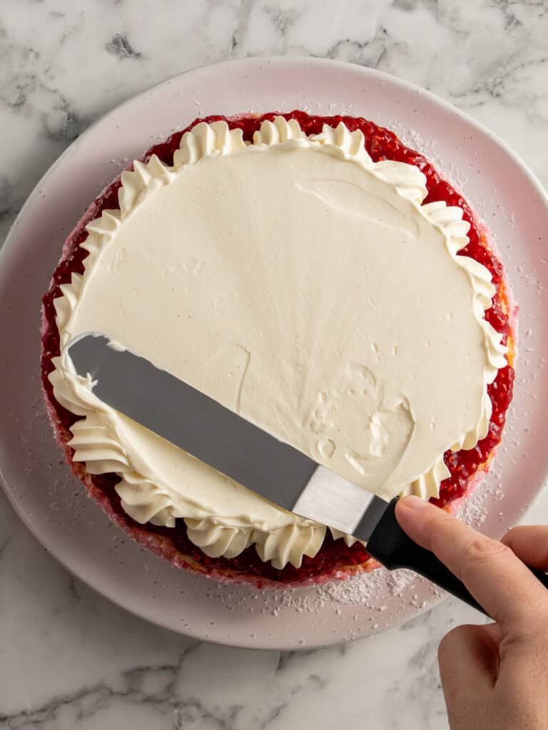 Spreading the cream on top of the sponge