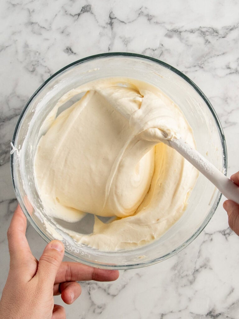 Folding the eggs and dry ingredients together to finish the cake batter