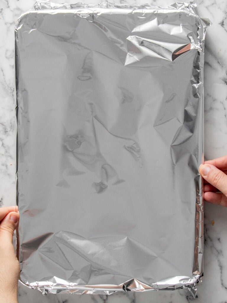 Covering the cake with foil to let it cool down as it traps the steam