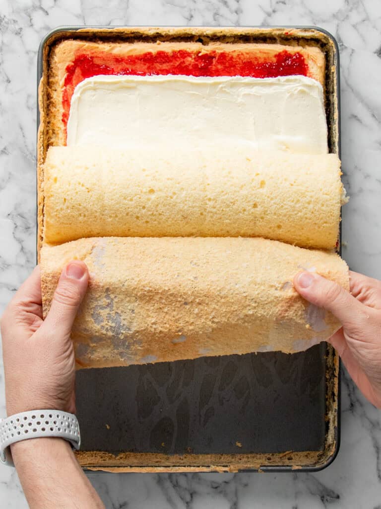 Using the baking paper to roll the sponge over itself