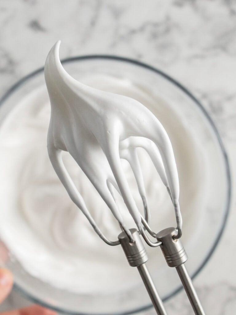 Showing how thick and glossy the meringue is on the beaters