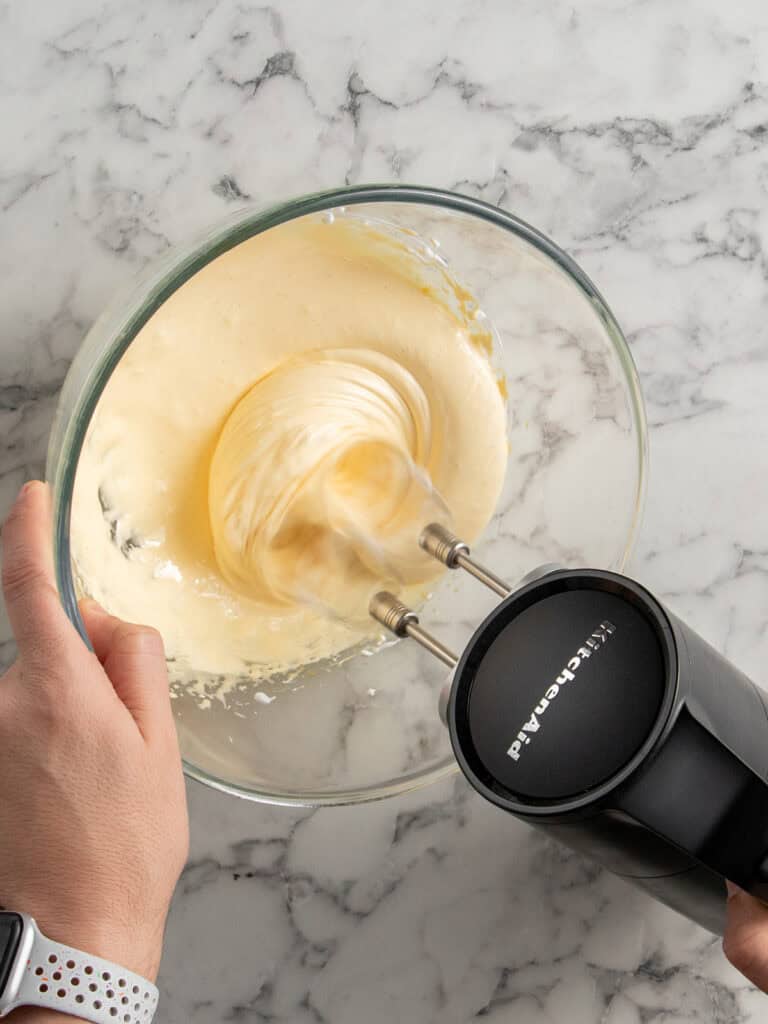 Whisking the sugar and egg yolks until pale and creamy