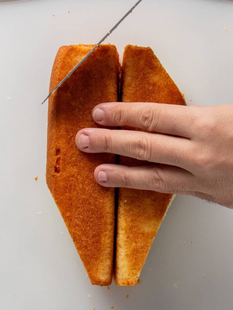 Slicing off the back and front of the square cake to create the front and back of the duck