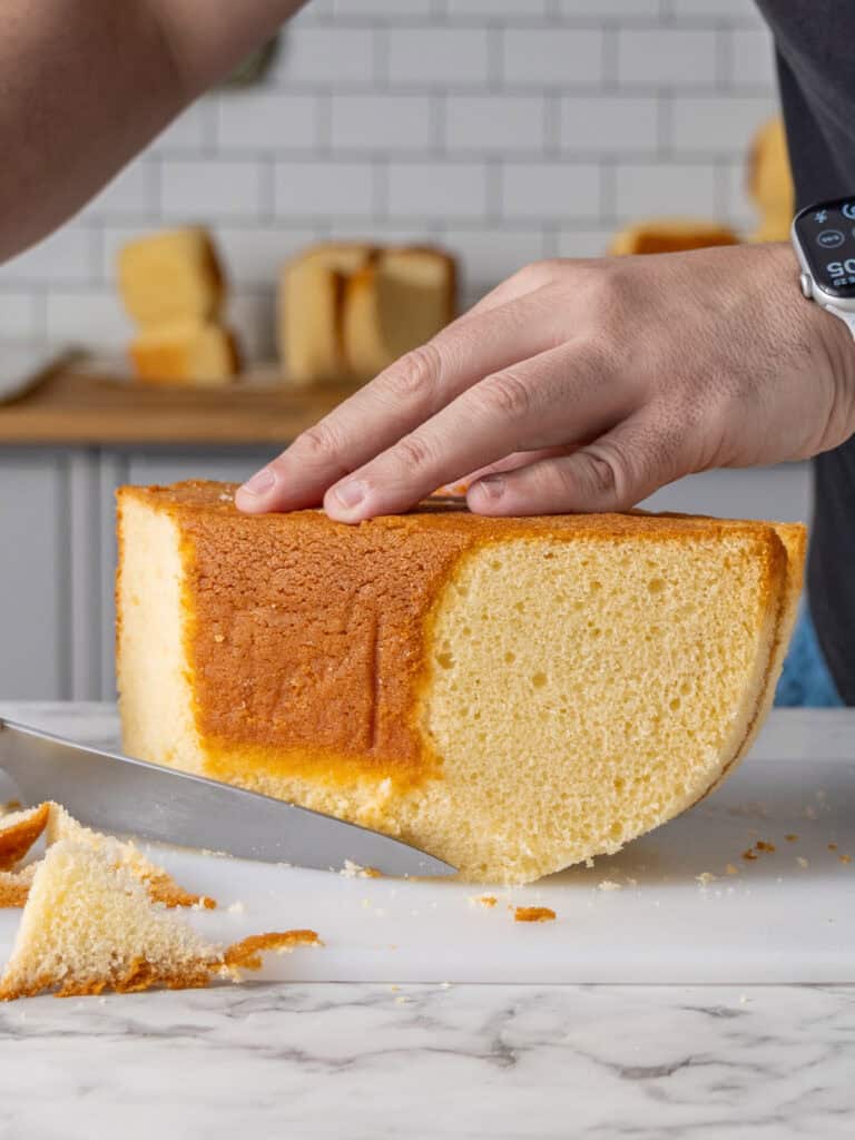 Slicing a round wedge on the side of the square cake for the ducks body