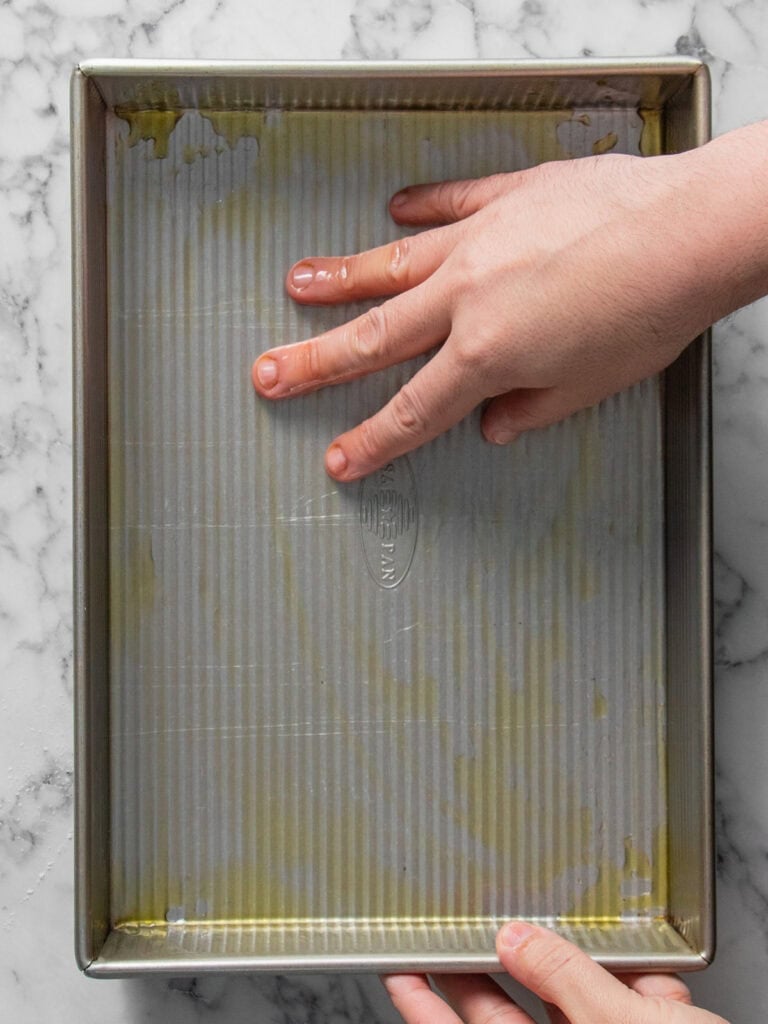 Covering the baking dish in olive oil before baking