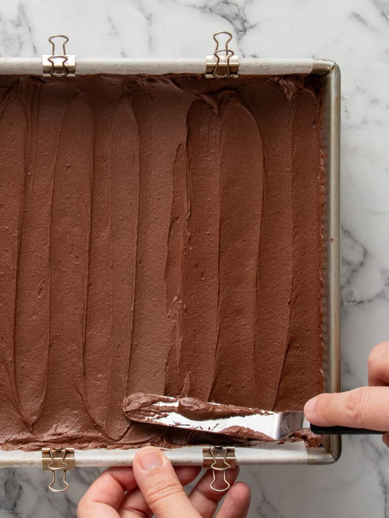 Top down shot of frosting being spread on brownies