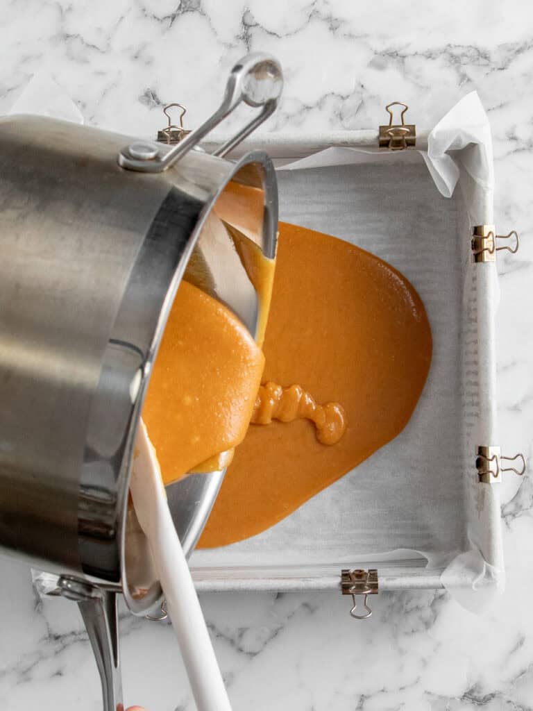 Adding the caramel to the lined baking tin