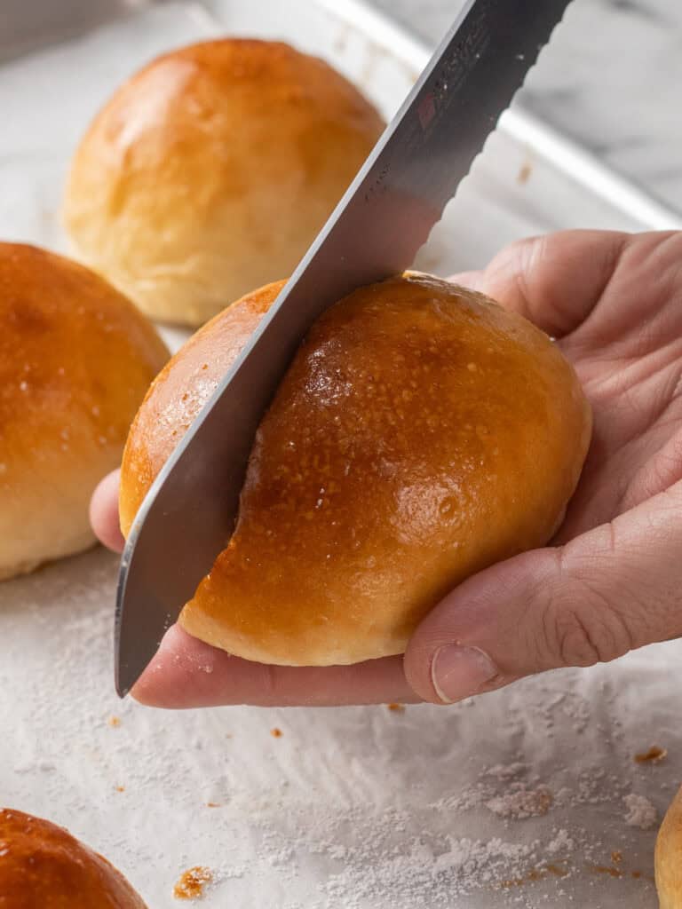 Slicing the finished bun in half using a serrated knife