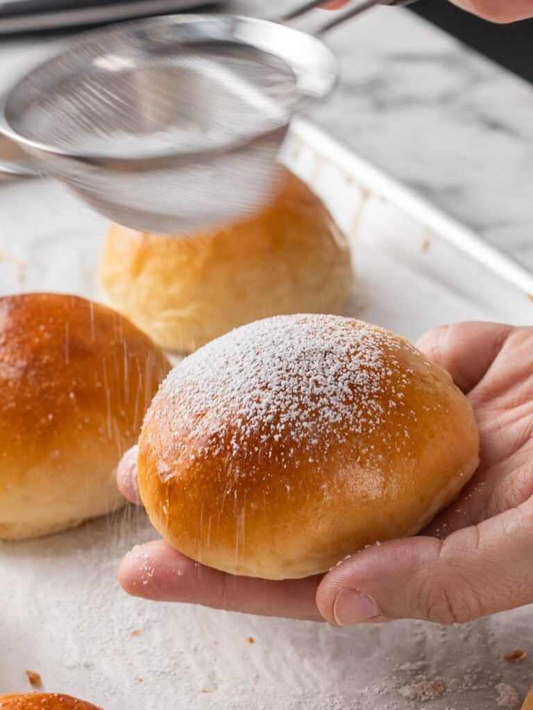 Dusting the sliced bun with icing sugar