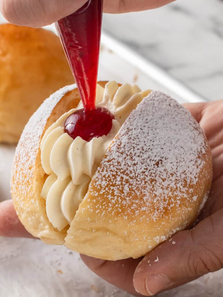 Piping some more raspberry jam on top to finish it off