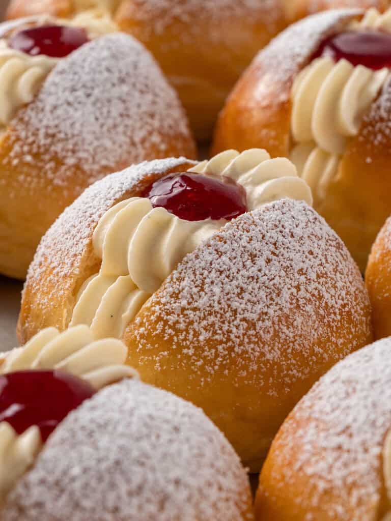 Extreme close up shot of brioche buns with Chantilly and raspberry jam