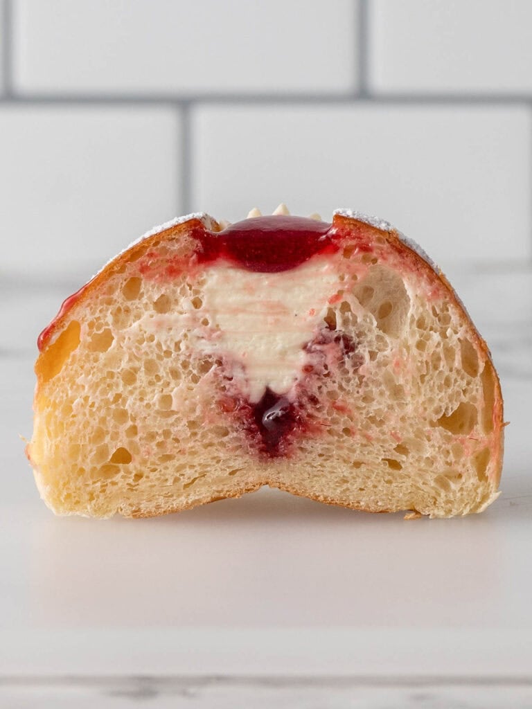 Showing the middle of the brioche bun when it's been filled with Chantilly and jam