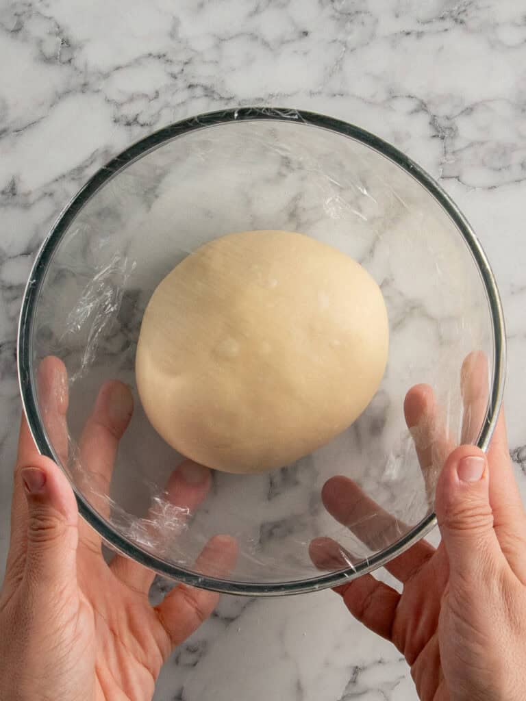 Putting it in a large bowl and covering it with plastic wrap for the first rise at room temperature