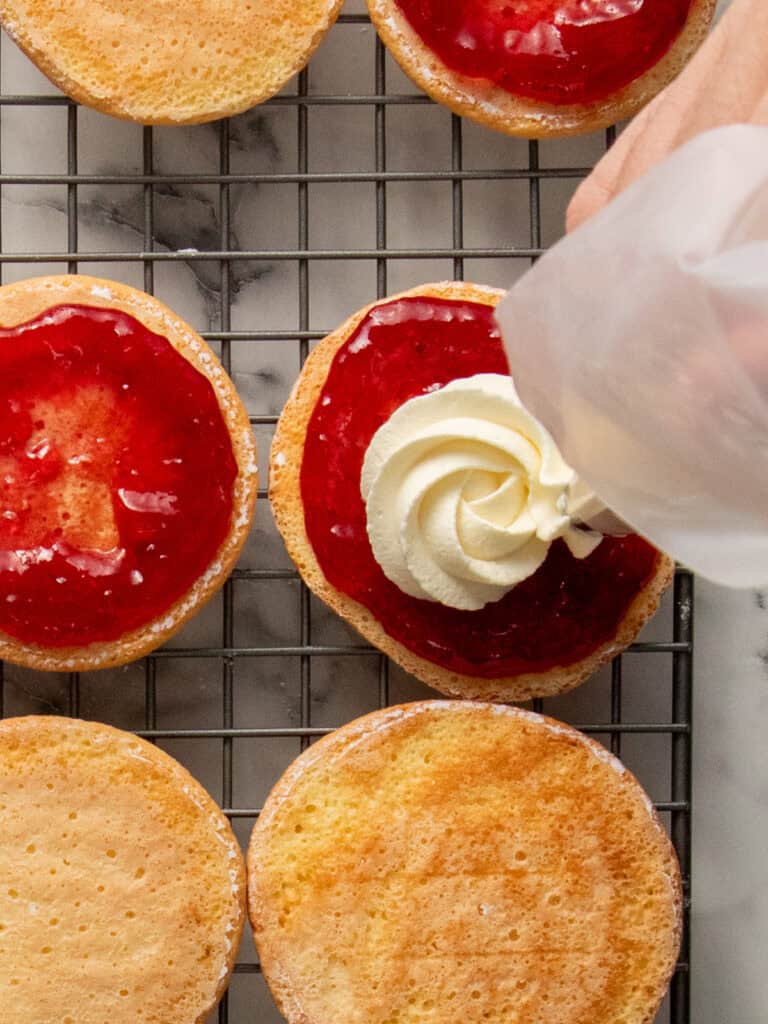 Piping Chantilly cream on top of the sponge cakes